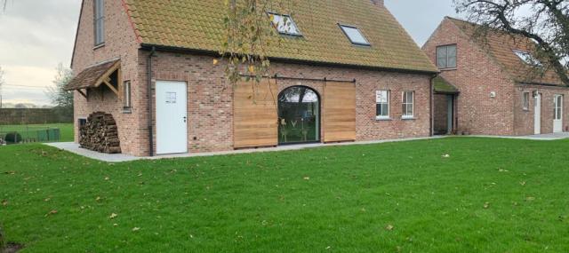 Atelier Origine met buitenschrijnwerk met een eiken oversteek en een eiken houten poorten voor buiten te wingene west vlaaderen