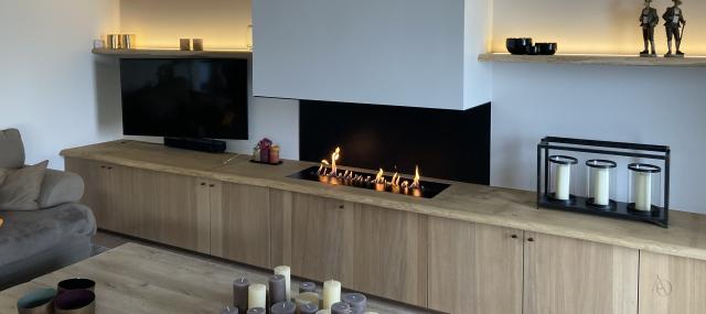 Atelier Origine heeft deze prachtige haardwand/tv wand afgewerkt met eik fineer maatwerk en een massieven eiken blad met open haard
